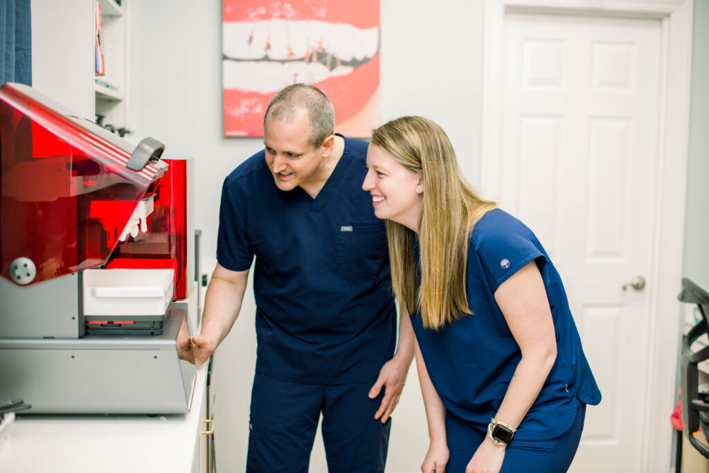 Dr. Adam Bozeman and other nurse looking at a machine.