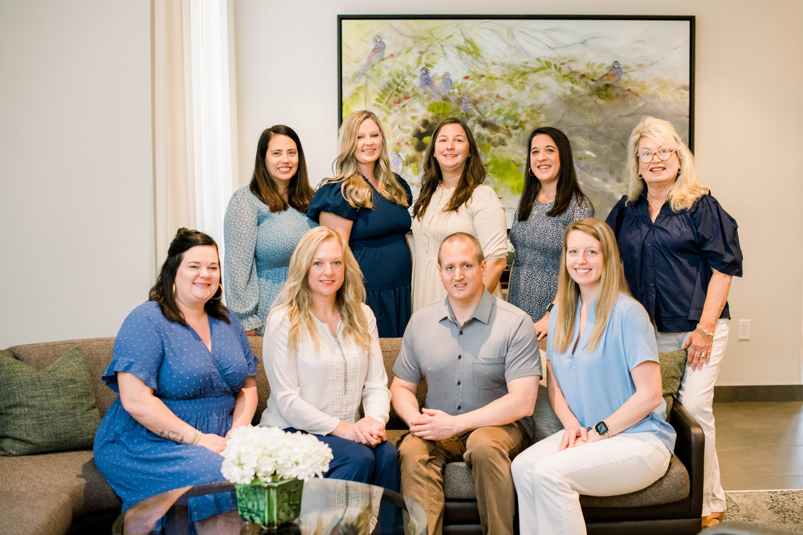 The dental team of Bozeman Dental smiling and posing together in a group photo.
